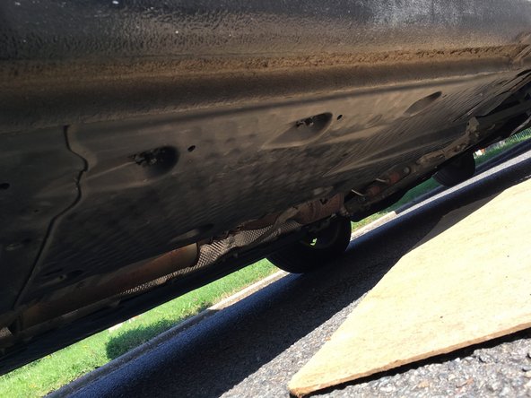 Dévisser les vis qui soutiennent la protection plastique, à l'aide de la clé de 10mm.