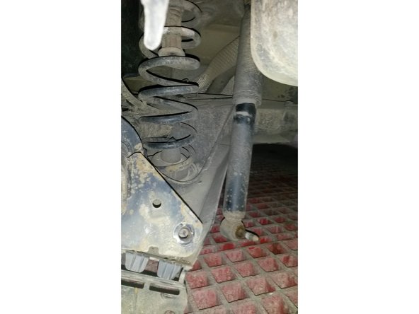 Retirez la fixation basse de l'amortisseur gauche.