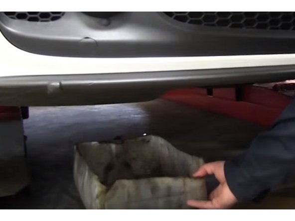 Placer un bac sous la voiture coté filtre pour récupérer l'huile