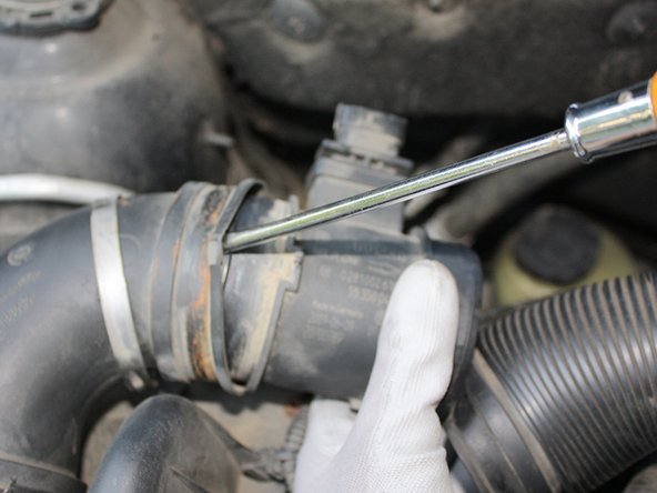 Enfin déboîter le conduit de gauche toujours à l'aide du tournevis plat et déposer le débitmètre.