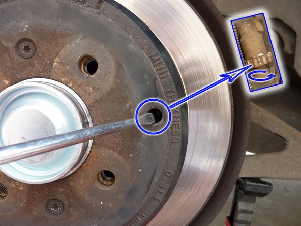 A l'aide d'un tournevis, faite tourner le boulon de réglage (repère bleu) dans le sens de la flèche jusqu'à ce que le disque ne puisse plus tourner. Desserrer de 5 crans en sens inverse afin de libérer en rotation le disque. Repositionner l'oburateur en caoutchouc en vous aidant d'une pince à bec.