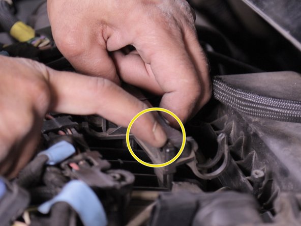 Appuyer sur les deux languettes de chaque coté du support de la pompe d’Amorçage placé devant la boite à, air puis retirer le