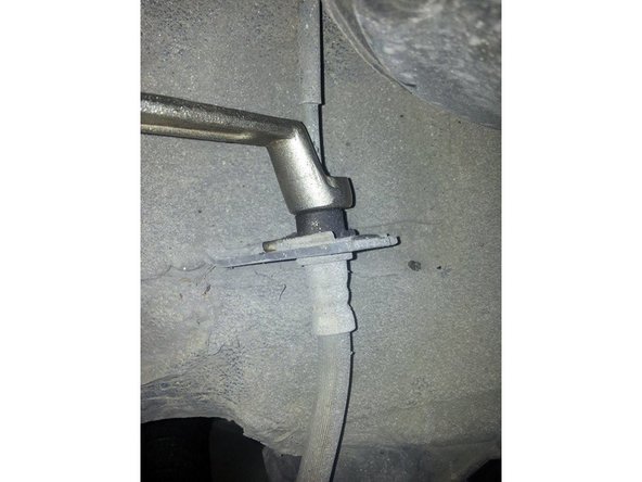 En utilisant impérativement une clé à tuyauter de la bonne taille (sous peine d'arrondir l'écrou) déposer l'écrou du raccord de la conduite rigide.