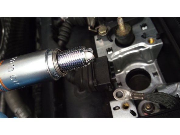 Mettre d'abord la bougie dans la douille puis la visser à la main à l'aide de la rallonge