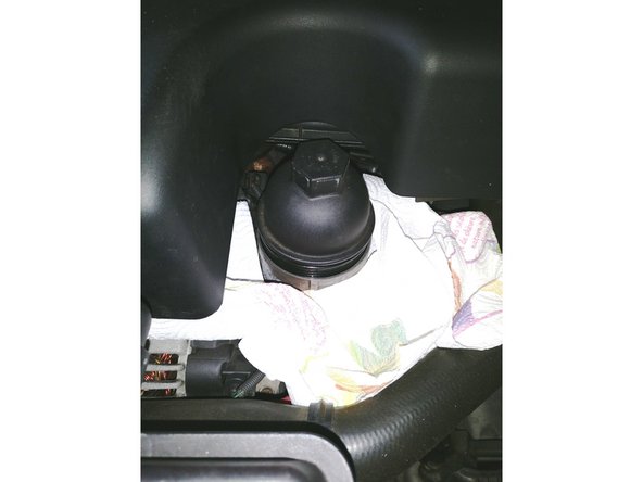 A l'aide d'un cliquet, d'une rallonge et d'une douille de 32, desserrer la filtre à huile sans le sortir