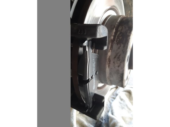 On commence par mettre en place la plaquette neuve côté piston qui est maintenue grâce a un ressort fixé sur la plaquette puis l'autre plaquette directement sur le disque.