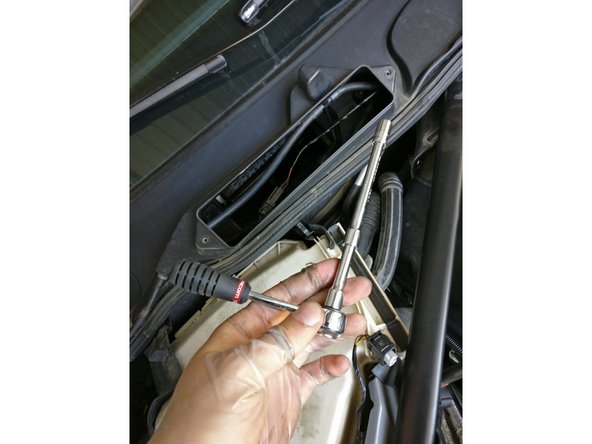 Une des vis est cachée sous les gaines protectrices, vous devrez utiliser une rallonge pour l'atteindre