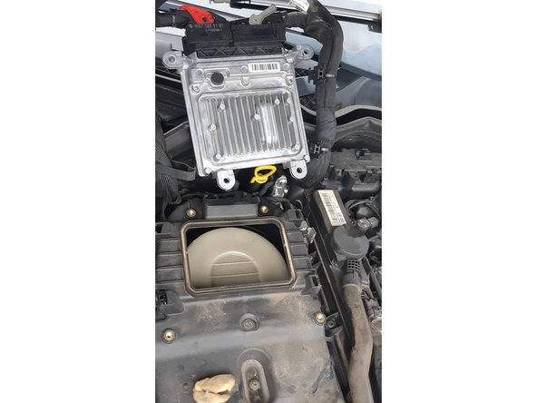 on devisse les 4 vis (8mm) qui maintiennent le calculateur, puis on coulisse tous les clips de maintien des câbles latéraux, et on bascule le tout (cables et calculateur) en arrière