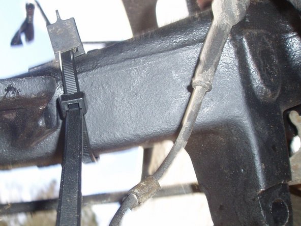 Remettre en place les éléments de fixation du tuyau de frein et de l'alimentation du capteur ABS en lieu et place sur les bras d'essieux à l'aide de colliers Colson.