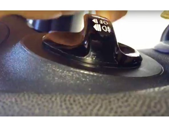 Insérer le petit tournevis à fente et l'enfoncer à fond dans le trou situé sous le bouton de commande en tirant sur celui-ci.