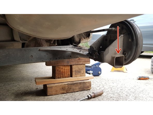 Appuyez sur l'essieu afin de laisser suffisamment d'espace pour sortir la jambe de force.