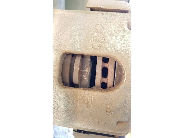 Insérez un gros tournevis plat entre le disque et la plaquette côté intérieur et faîtes levier pour repousser le piston.