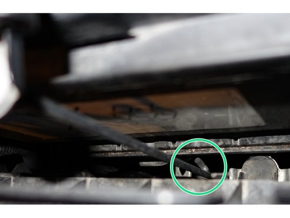 En faisant un quart de tour avec la tige,  la décrocher du support, sous la batterie.