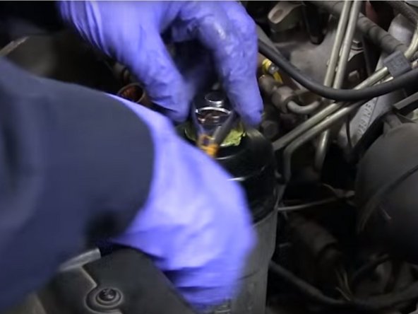 Resserrer la cloche à l'aide de la clé a filtre et du cliquet