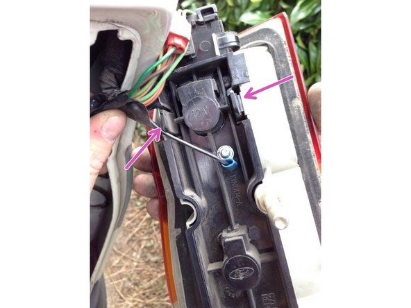 Présentez le cache en plastique noir dans le phare, puis appuyez fortement sur les deux clips disponible sur le cache, les clips sont sur le haut ainsi que le bas du cache des ampoules.