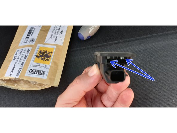 Ici les deux ergots à dégager en dernier lors du soulèvement du capot.