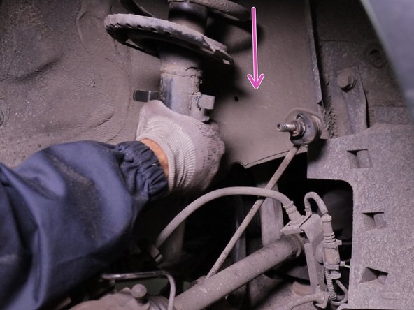 Retirer l'amortisseur en commençant par le bas puis le laisser descendre