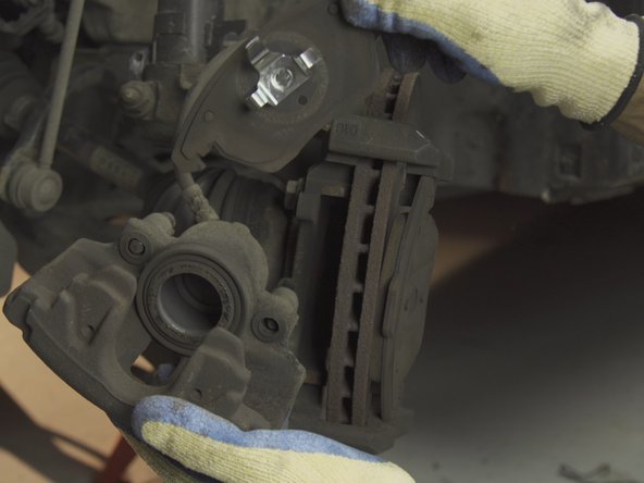 Pousser sur les deux oreilles de la plaquette présente dans le piston pour la libérer