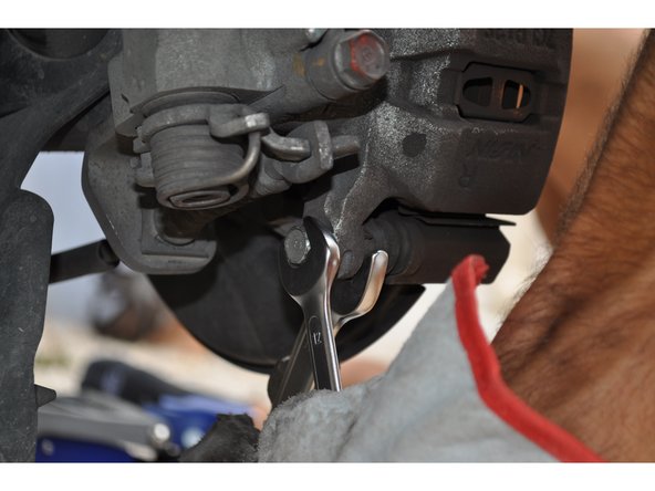 Pour déposer l'étrier de frein, dévisser les deux vis de fixation avec une clé de 12 mm et 17 mm.