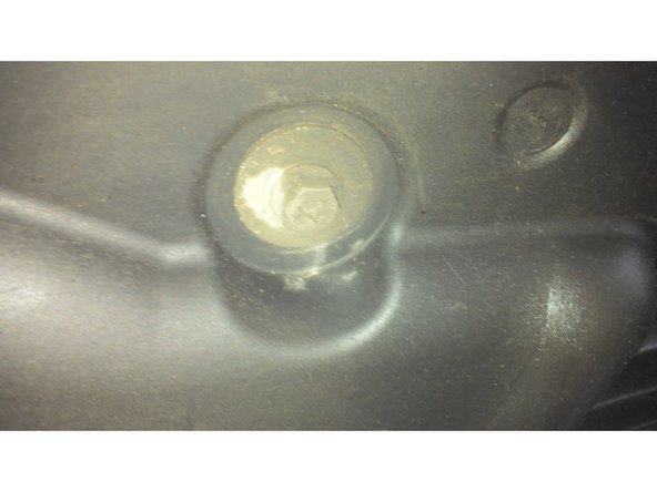 Appuyer  sur les éléments de fixation du cache plastique au niveau du ressort