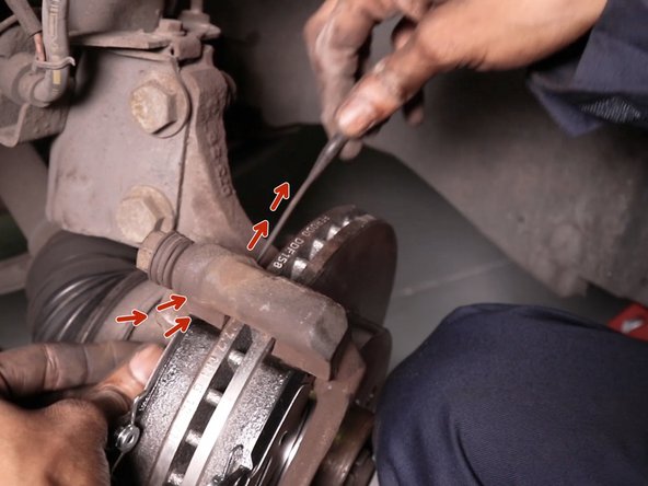 Faites passer le témoin d'usure sous le haut du support d’étrier afin de le glisser de l'autre coté