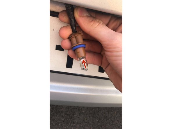 Maintenir le support marron et pousser l'ampoule