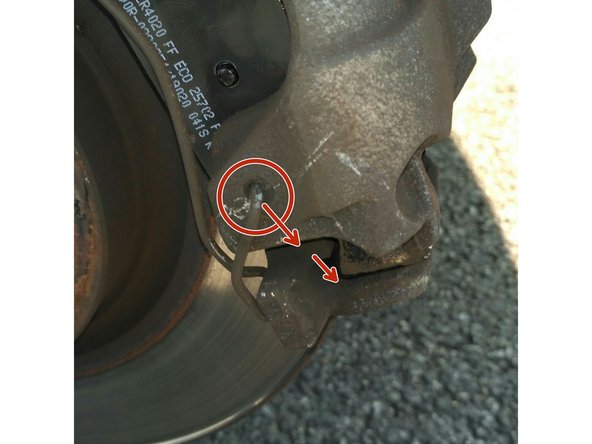 A l'aide d'une pince, enlever un côté de l’agrafe qui maintient l'étrier. Pour cela, tirer sur l’agrafe au niveau d'un de ses deux trous de fixation (ici entouré en rouge)