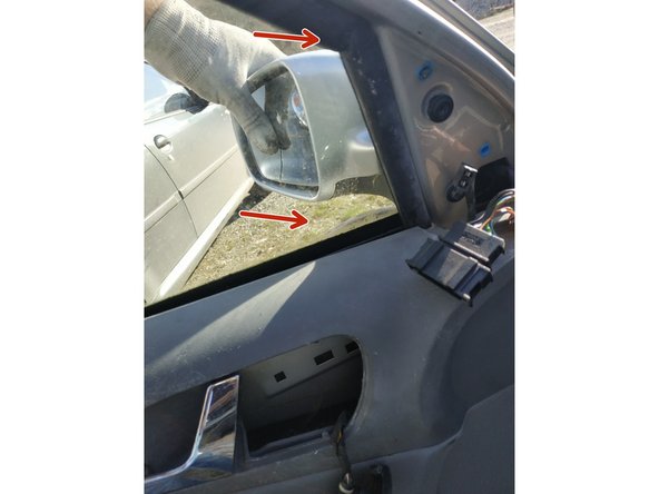 tout en maintenant le rétroviseur plaqué d'une main