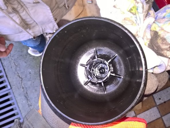 Protéger autour de la cloche avec des chiffons pour éviter  les coulures d'huile. On voit ici le tenon du filtre avec le joint torique qui ouvre le retour de l'huile usagée vers le moteur lors de la dépose. Tirer fortement sur le filtre pour le séparer de la cloche. Nettoyer la cloche et le support du filtre.