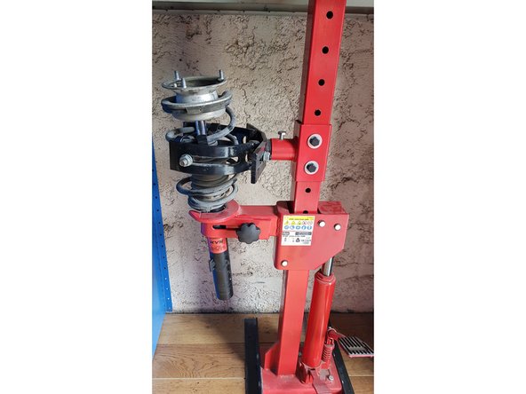 Compressez le ressort jusqu'à ce que la coupelle soit libre.