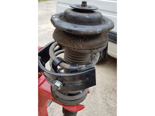 Compressez le ressort jusqu'à ce que la coupelle soit libre.