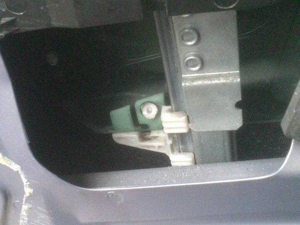 Remettre la vite en place, toujours en faisant bien attention. Elle doit être alignée à l'avant dans le rail fixe (flèche bleue) et reclipsée sur ses 2 supports en plastique blanc.