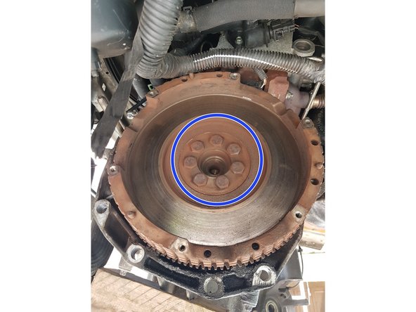 Déviser les 7 vis qui retiennent le volant moteur. Bloquer le volant moteur pour pouvoir les enlever.