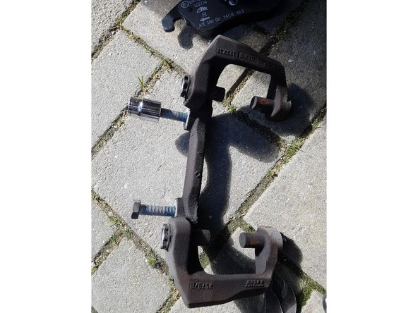 A l'aide d'une douille de 18mm desserrer les 2 boulons du support étrier ( leur serrage est très fort).