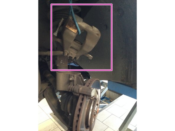 Déposer l’étrier en le faisant coulisser vers la gauche, et le suspendre à l'amortisseur.