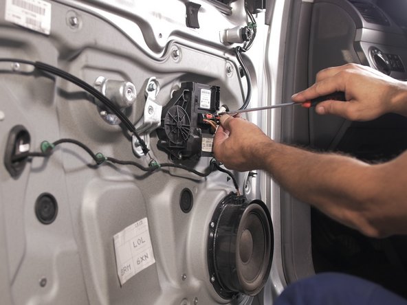 A l'aide d'un petit tournevis plat, déverouiller et tirer sur le connecteur de réglage du rétroviseur pour le déconnecter