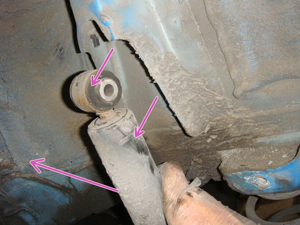 Saisir le haut de l'amortisseur, appuyer vers le bas pour le comprimer, afin de le sortir de son logement supperieur  avant de le pivoter pour le dégager complètement