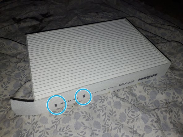 Voilà le nouveau filtre, avec des flèches indiquant le sens de circulation de l'air. Comparer les dimensions des deux filtres.