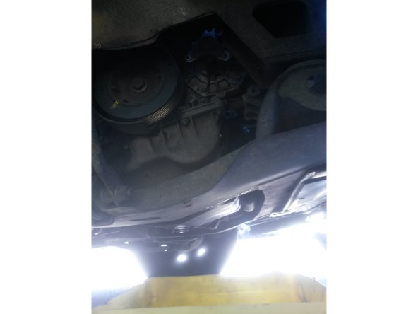 Mettre un récipient sous la voiture avant de dévisser la pompe à eau le liquide de refroidissement va s'écouler.