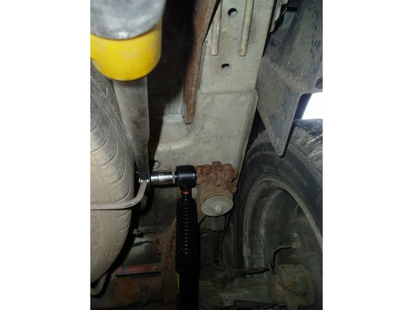 Serrer les écrous supérieurs des amortisseurs gauche et droit au couple de 7 Da N.m