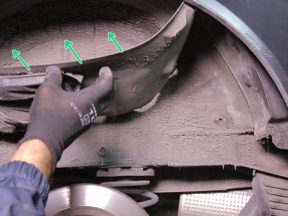 Écarter une partie du pare boue afin d’accéder aux  amortisseurs