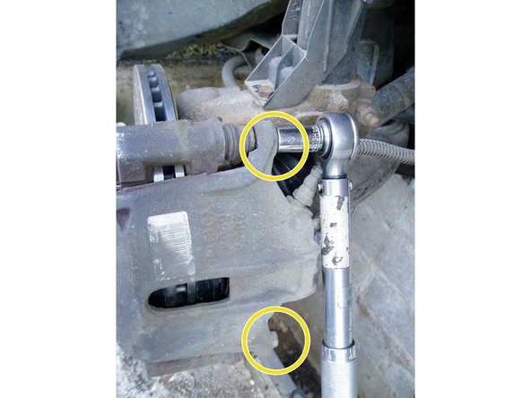 Mettre en place l'étrier à l'aide des 2 vis  sur les colonnettes et une douille de 13. Serrer à 3 daN.m