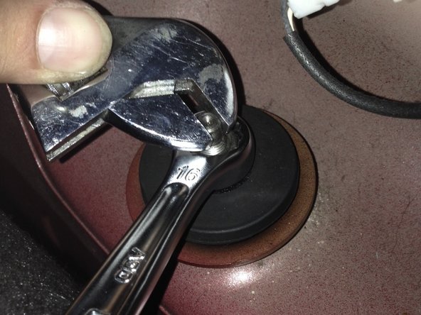 À l'intérieur du coffre, finir de visser le boulon de serrage (environ 2daN-m) tout en maintenant le goujon à l'aide de la clé à molette.