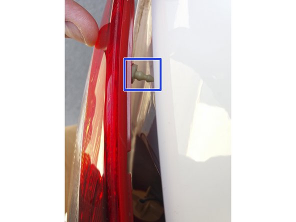 Aligner les 2 ergots du feu devant leur logement dans la carrosserie.