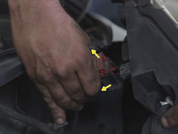 Débrancher le connecteur placé derrière le phare, à l'aide d'un tournevis plat lever le verrouillage rouge pour le faire coulisser en arrière