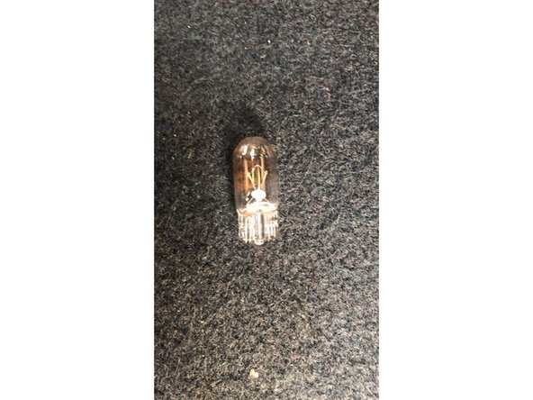 Maintenir le support marron et pousser l'ampoule