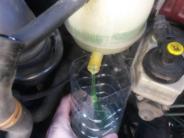 Faire tourner la durite afin de la décoller du vase d'expansion