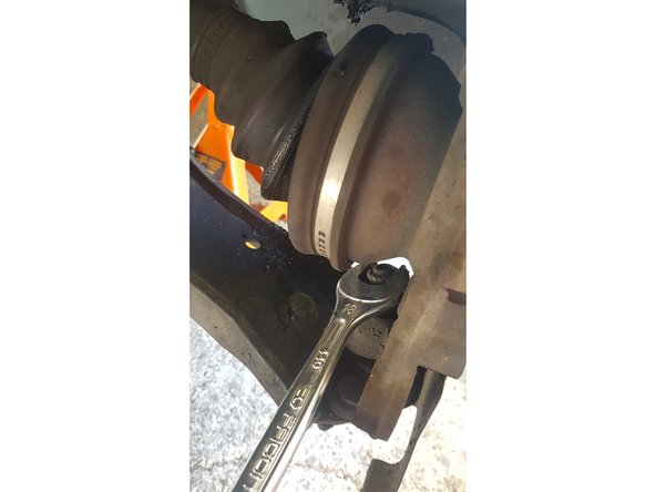 Avec une clé de 18mm retirez l'écrou de la rotule de suspension.