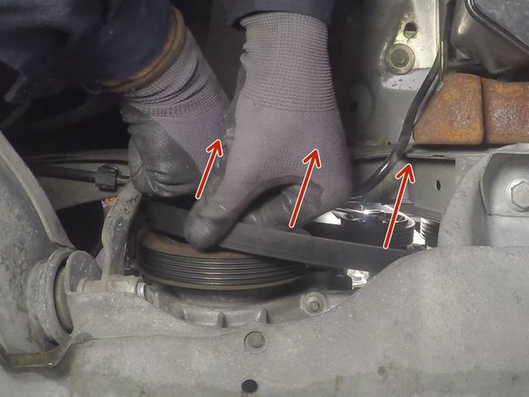 Maintenir la clé en position pour dégager la courroie de la poulie du vilebrequin