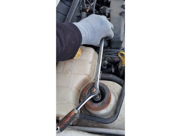 La jambe de force ne tient que par cet écrou. Une fois dévissé, il ne faut pas qu'elle tombe sur le flexible de frein.